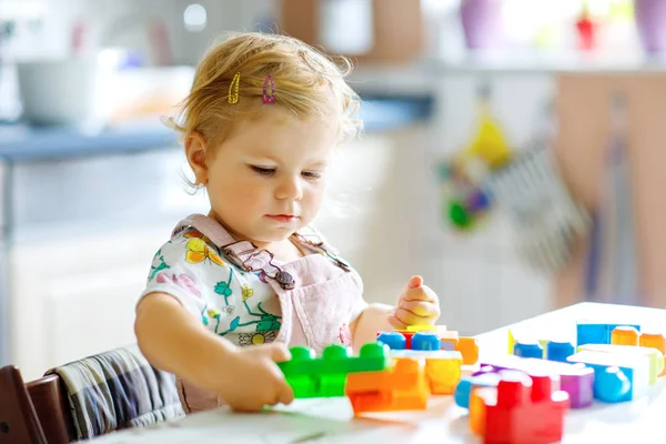 Förtjusande liten flicka leker med pedagogiska leksaker i barnkammaren. Glad frisk barn att ha kul med färgglada olika plastblock hemma. Söt baby lärande skapa och bygga. — Stockfoto