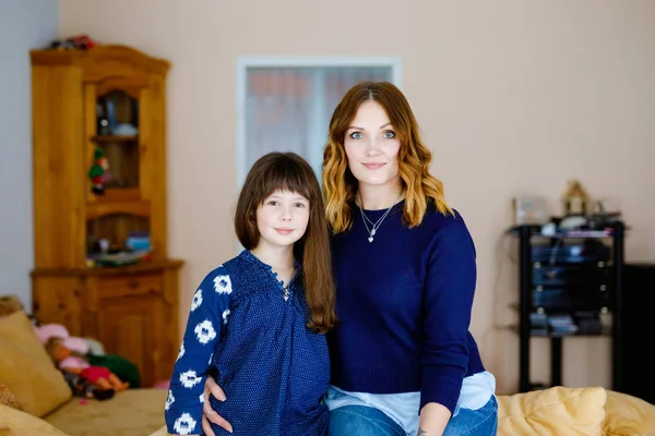 Adorable niña de la escuela con hermosa madre joven. Feliz retrato familiar sano, mamá amor y felicidad, abrazos y besos. Mujer y lindo niño . —  Fotos de Stock