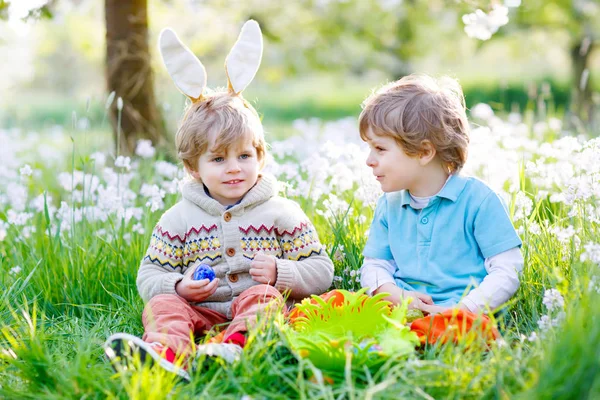 Dva malí kluci přátelé v velikonoční zajíček uši během hon na vejce — Stock fotografie