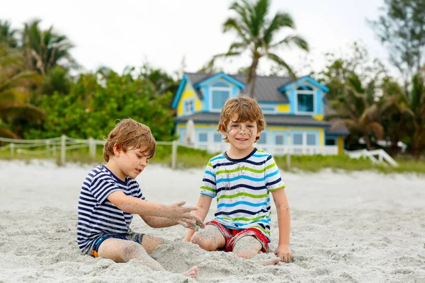 İki küçük çocuklar dostluk kavramı eğleniyor tropik sahilde oynarken, mutlu arkadaşlarım çocuğu. Kardeş kardeş, İkizler aile arka plan üzerinde avuç içi ile bak. Haiti aile tatil. — Stok fotoğraf