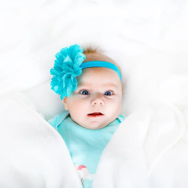 Lindo bebé recién nacido adorable en cama blanca y envuelto en manta. Niño recién nacido, niña mirando sorprendida a la cámara. Familia, nueva vida, infancia, concepto inicial —  Fotos de Stock