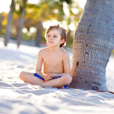 Sarışın küçük çocuk çocuk Miami beach, Key Biscayne üzerinde eğleniyor. Kumla oynayan ve okyanus yakın çalışan mutlu sağlıklı sevimli bir çocuk. Avuç içi, güvenlik ev ve beyaz kum. Güneşli sıcak parlak ışık ile