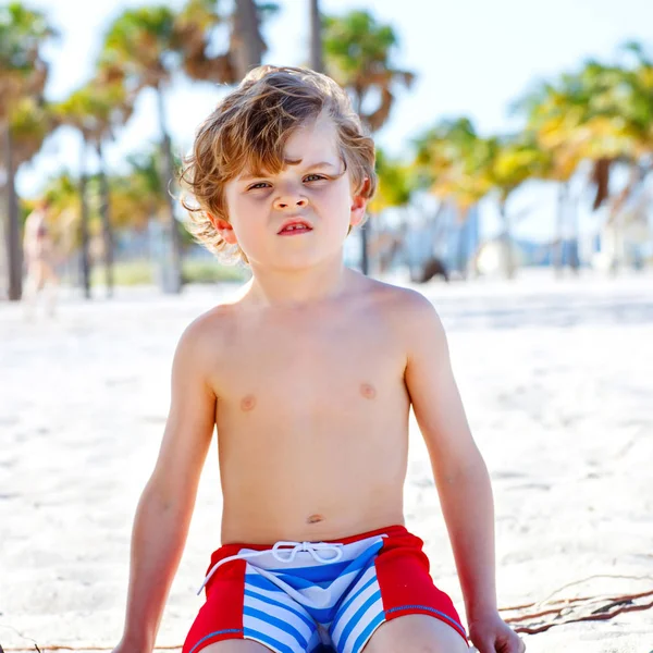 Adorable niño activo divirtiéndose en la playa de Miami, Key Biscayne. Feliz niño lindo relajante, jugando y disfrutando de un día soleado y cálido cerca de las palmas y el océano — Foto de Stock