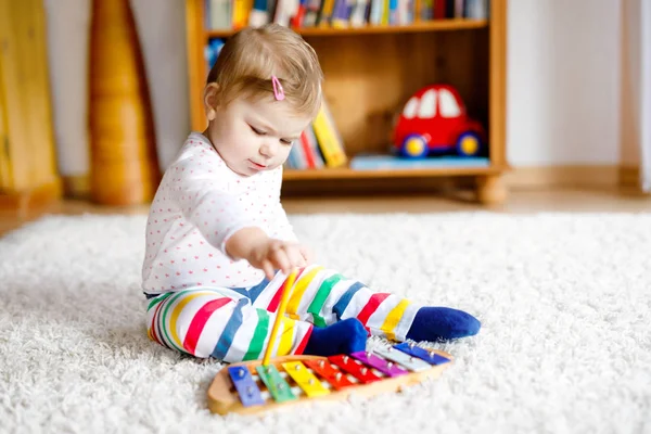 Adorable linda y hermosa niña jugando con juguetes educativos en casa o en la guardería. Feliz niño sano divirtiéndose con colorido juguete musical xilófono niño aprendiendo diferentes habilidades —  Fotos de Stock