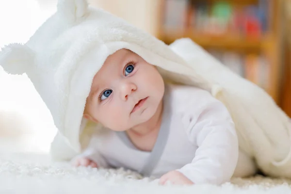 Meisje van de baby dragen witte handdoek of winter overal in witte zonnige slaapkamer — Stockfoto