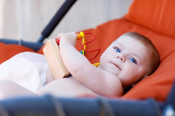 Adorável bebê recém-nascido brincando com colorido brinquedo chocalho educacional de madeira — Fotografia de Stock