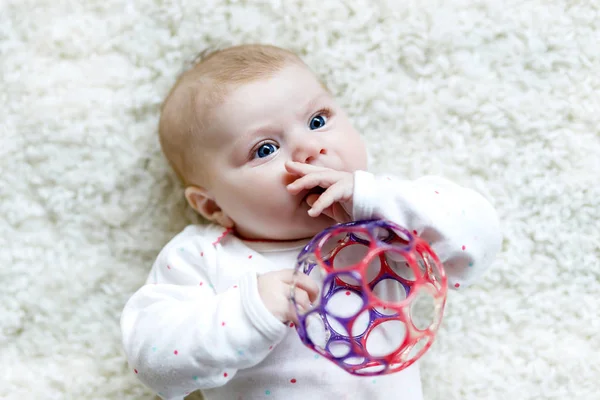 Linda niña jugando con colorido juguete sonajero —  Fotos de Stock