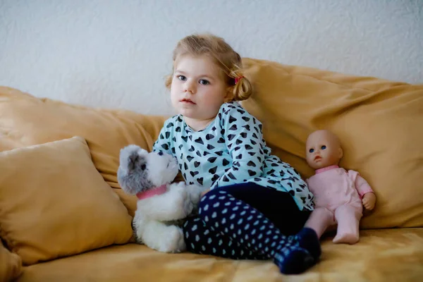Мила маленька дівчинка в піжамі нічного одягу дивиться мультфільми або фільм по телевізору. Щаслива здорова дитина вдома . — стокове фото
