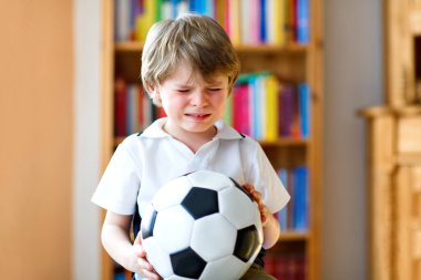 Futbol topu olan sarışın anaokulu çocuğu TV 'de futbol maçı izliyor. En sevdiği futbol takımının kaybettiği maç yüzünden üzgün, ağlayan ve bunalımda olan bir çocuk. Şampiyonlar ve Dünya Kupası konsepti