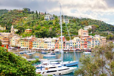 Portofino 'nun küçük limanında renkli evleri, lüks tekneleri ve yatları olan güzel küçük bir köyü var. Liguria, İtalya. Sıcak bir yaz gününde