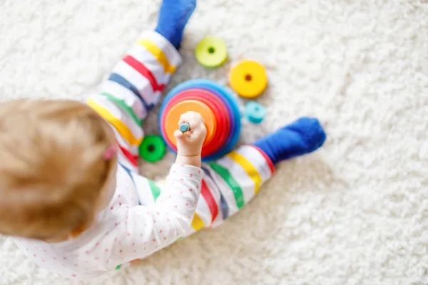 Schattig schattig mooi klein meisje spelen met educatief speelgoed thuis of in de kinderkamer. Gelukkig gezond kind hebben plezier met kleurrijke houten regenjongen speelgoed piramide. Kind dat verschillende vaardigheden leert — Stockfoto