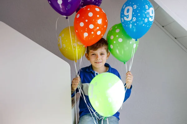 Doğum gününde renkli balonlarla gezen mutlu çocuk portresi. Gülümseyen okul çocuğu dokuzuncu doğum gününü kutluyor. Aile ve en iyi arkadaş partisi — Stok fotoğraf