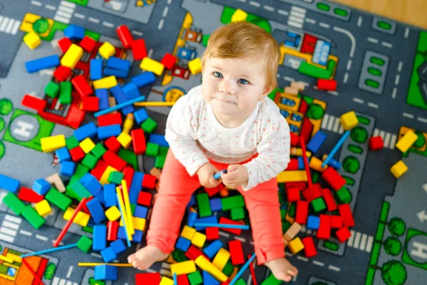 Entzückendes kleines Mädchen, das mit Lernspielzeug spielt. Glückliches gesundes Kind, das mit bunten Holzklötzen zu Hause im häuslichen Raum Spaß hat. Baby lernt Farben und Formen — Stockfoto