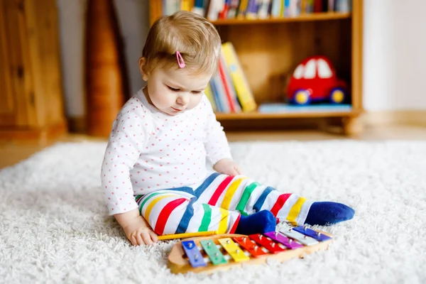 Adorable linda y hermosa niña jugando con juguetes educativos en casa o en la guardería. Feliz niño sano divirtiéndose con colorido juguete musical xilófono niño aprendiendo diferentes habilidades —  Fotos de Stock