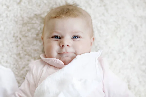 Close-up of a two or three months old baby girl with blue eyes. Newborn child, little adorable peaceful and attentive girl looking surprised at the camera. Family, new life, childhood concept. — Stock Photo, Image
