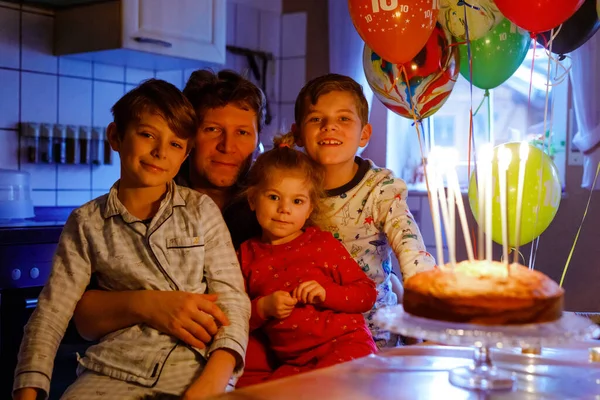 10. yaş gününü kutlayan sevimli çocuk. Bebek bebek, iki çocuk erkek kardeş ve baba pasta ve mumlarla birlikte. Üç çocuklu sağlıklı bir aile fotoğrafı. — Stok fotoğraf