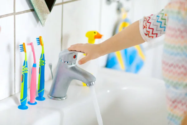 Close-up van kleine peuter meisje wassen handen met zeep en water in de badkamer. Close-up kind leren schoonmaken lichaamsdelen. Hygiëne routine actie tijdens virale desease. kind thuis of in de kinderkamer. — Stockfoto