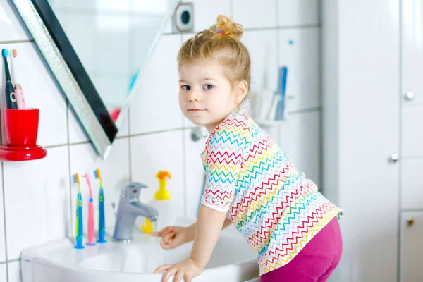 Schattig klein peuter meisje wassen handen met zeep en water in de badkamer. Schattig kind leren schoonmaken lichaamsdelen. Hygiëne routine actie tijdens virale desease. kind thuis of in de kinderkamer. — Stockfoto