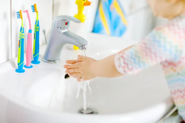 Gros plan de petite fille tout-petit se lavant les mains avec du savon et de l'eau dans la salle de bain. Gros plan enfant apprendre à nettoyer les parties du corps. Hygiène action de routine pendant la maladie virale. enfant à la maison ou à la crèche. — Photo