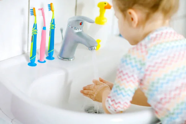 Gros plan de petite fille tout-petit se lavant les mains avec du savon et de l'eau dans la salle de bain. Gros plan enfant apprendre à nettoyer les parties du corps. Hygiène action de routine pendant la maladie virale. enfant à la maison ou à la crèche. — Photo