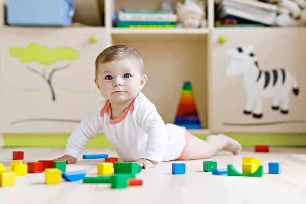 Cute baby girl playing with colorful rattle toys — Stock Photo, Image