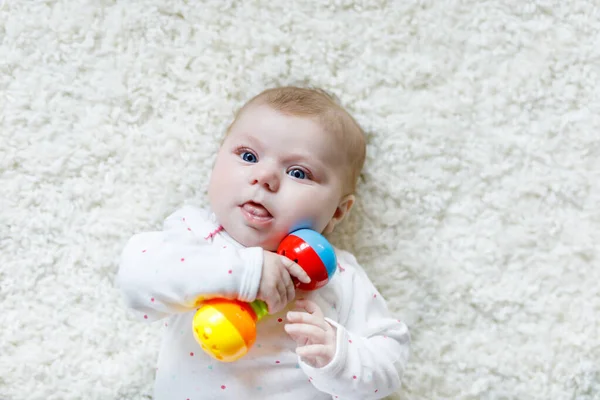 Bonito bebê menina brincando com colorido chocalho brinquedo — Fotografia de Stock