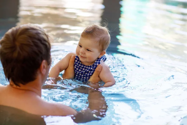 Glücklicher Vater mittleren Alters schwimmt mit süßen entzückenden kleinen Mädchen im Schwimmbad. — Stockfoto