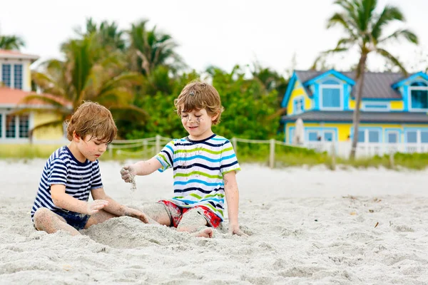 İki küçük çocuk tropik sahilde eğleniyor. — Stok fotoğraf