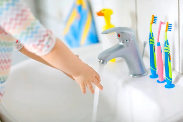 화장실에서 비누와 물로 손을 씻는 어린 소녀의 모습이 감겨져 있다. 가까이 있는 아이가 몸을 청소하는 법을 배우게 하 십시오. 바이러스가 꺼림칙 할 때 위생적 인 일상 행동을 하는 거죠. 집이나 보육원에 있는 아기. — 스톡 사진