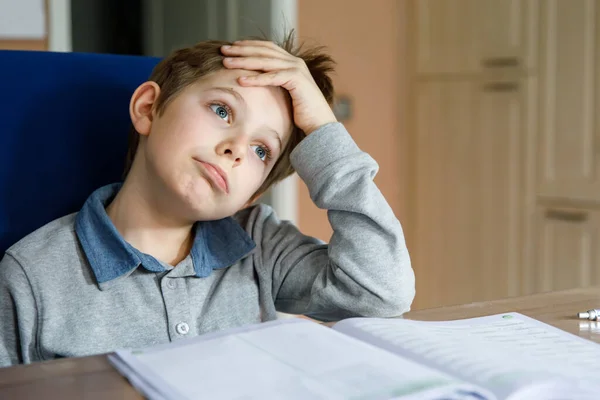 Niño de la escuela molesto haciendo tarea durante el tiempo de cuarentena de la enfermedad pandémica de corona. Llorando y triste chico frustrante quedarse en casa. —  Fotos de Stock