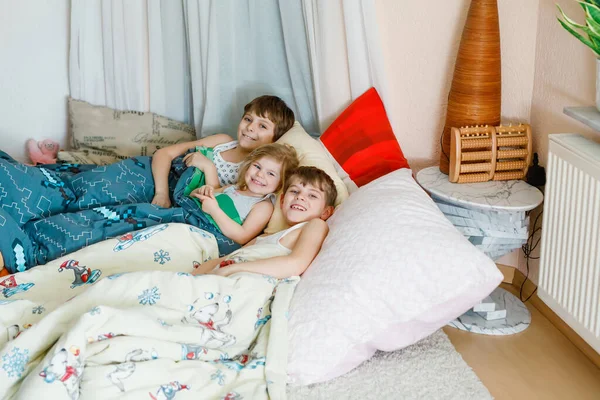 三个小孩在家里一起玩，被隔离了，不能感染结肠炎病毒。两个男学生和一个小女孩在屋里玩得很开心。活跃的儿童。待在家里的概念. — 图库照片