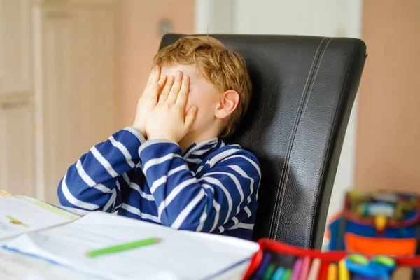 Menino da escola perturbado fazendo lição de casa durante o tempo de quarentena de doença pandêmica corona. Chorando e triste menino frustrante ficar em casa. Conceito de ensino em casa — Fotografia de Stock