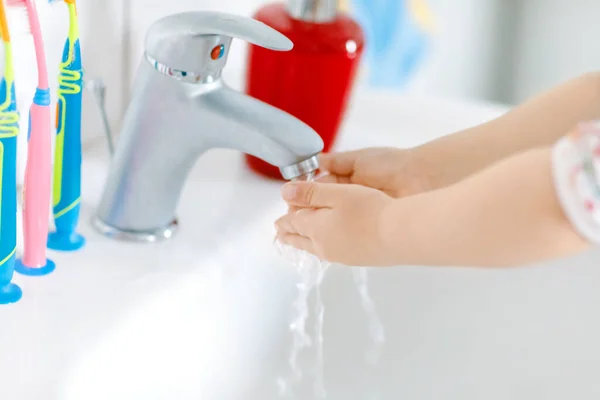 Närbild av små barn flicka tvätta händerna med tvål och vatten i badrummet. Närbild barn lär rengöring kroppsdelar. Hygien rutinåtgärd under virussjukdom. barn hemma eller på dagis. — Stockfoto