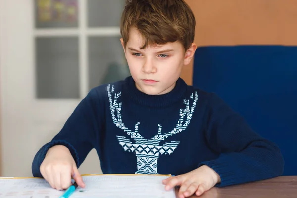 Hard werkende, vrolijke schooljongen die huiswerk maakt tijdens quarantainetijd door een corona pandemie. Gezond kind schrijven met pen, thuis blijven. Begrip "thuisonderwijs" — Stockfoto