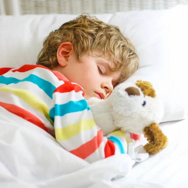 Pequeño niño rubio en ropa de dormir colorida — Foto de Stock