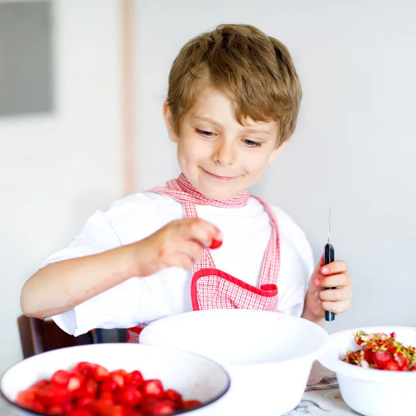 Little blond kid boy helping and making strawberry jam in summer — Stock Photo, Image