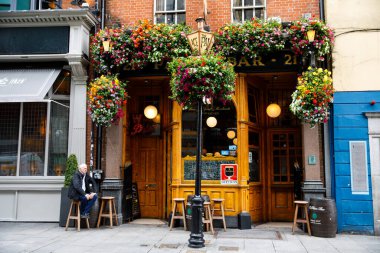 DUBLIN, IRELAND - 1 Temmuz 2019: Temple Bar semti Dublin 'in kültürel bölgesinde her yıl binlerce turist tarafından ziyaret edilen ünlü bir simgedir. İrlanda başkentinin merkezi - erkek kadın turistler