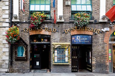 DUBLIN, IRELAND - 1 Temmuz 2019: Temple Bar semti Dublin 'in kültürel bölgesinde her yıl binlerce turist tarafından ziyaret edilen ünlü bir simgedir. İrlanda başkentinin merkezi - erkek kadın turistler