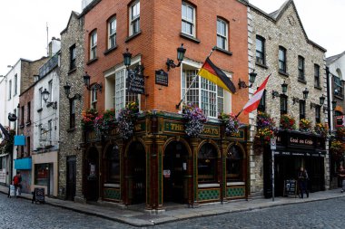 DUBLIN, IRELAND - 1 Temmuz 2019: Temple Bar semti Dublin 'in kültürel bölgesinde her yıl binlerce turist tarafından ziyaret edilen ünlü bir simgedir. İrlanda başkentinin merkezi - erkek kadın turistler