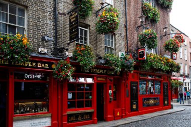 DUBLIN, IRELAND - 1 Temmuz 2019: Temple Bar Dublin kültürel bölgesinde her yıl binlerce turist tarafından ziyaret edilen ünlü bir simgedir. İrlanda başkentinin merkezindeki Tapınak Bar - erkek kadın
