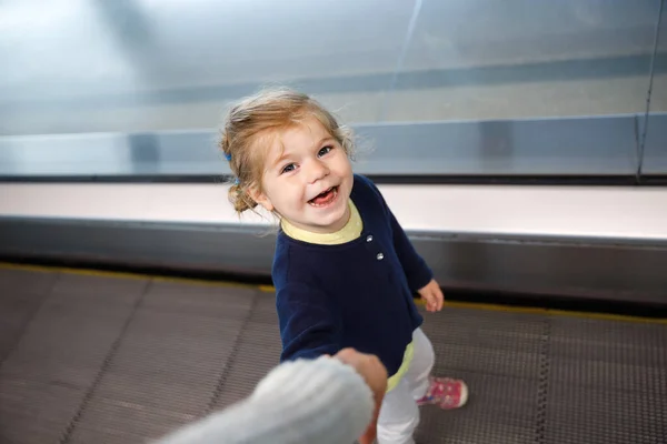 En söt liten flicka på flygplatsen. Härligt barn som går till grinden och åker på familjesemester med flyg. Positivt lyckligt barn. — Stockfoto