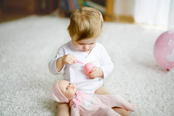 Heerlijk schattig mooi klein meisje spelen met speelgoed pop thuis of in de kinderkamer. Gelukkig gezond kind dat plezier heeft met ander speelgoed. Peuter die verschillende vaardigheden leert. — Stockfoto