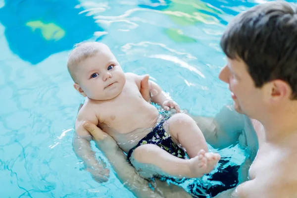 Buon padre di mezza età nuotare con carino adorabile bambino in piscina. Un padre sorridente e un bambino piccolo, una neonata che si diverte insieme. Famiglia attiva trascorrere il tempo libero e il tempo in hotel spa . — Foto Stock