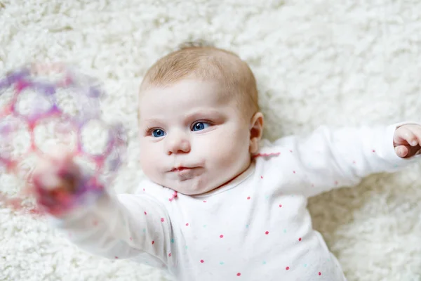 귀여운 갓난아기가 하얀 배경에 화려 한 공 놀이를 하고 있습니다. 새로 태어난 아이, 카메라를 보는 어린 소녀. 가족, 새 삶, 어린 시절, 컨셉 시작. 새끼키우기 요령. — 스톡 사진