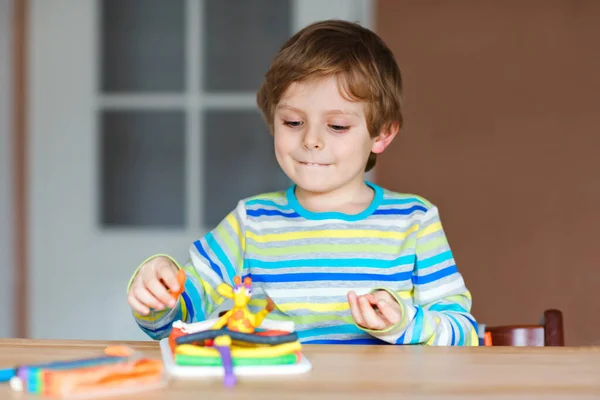 Ragazzo prescolastico sorridente che si diverte con pasta, argilla composta modellante colorata. Tempo libero creativo con i bambini. durante la quarantena del virus corona stare a casa. Rifugio in posizione, concetto di isolamento, — Foto Stock