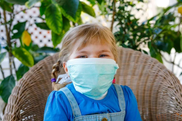 Menina pequena em máscara médica como proteção contra a doença de quarentena do coronavírus pandêmico. Criança bonito usando equipamentos de proteção como luta contra o covid 19 . — Fotografia de Stock