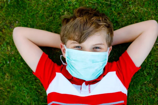 Чарівний хлопчик у медичній масці як захист від пандемії коронавірусної хвороби. Шкільна дитина використовує захисне обладнання як боротьбу з ковадлом 19 . — стокове фото