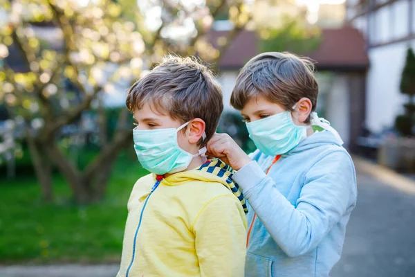 Zwei kleine Jungen in medizinischer Maske als Schutz vor der pandemischen Coronavirus-Krankheit. Kinder, liebe Geschwister und beste Freunde mit Schutzausrüstung im Kampf gegen Covid 19. — Stockfoto