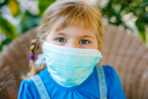 Маленька дівчинка-малятко в медичній масці як захист від пандемії коронавірусної хвороби. Мила дитина використовує захисне обладнання як боротьбу з ковадлом 19 . — стокове фото