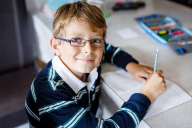 Çalışkan, mutlu okul çocuğu Corona salgınından dolayı karantina zamanında ödev yapıyor. Kalemle yazan sağlıklı bir çocuk, evde kalıyor. Evde eğitim kavramı